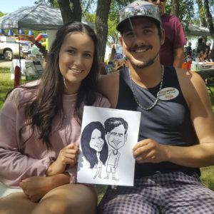 couple with caricature of themselves at outdoor festival martensville