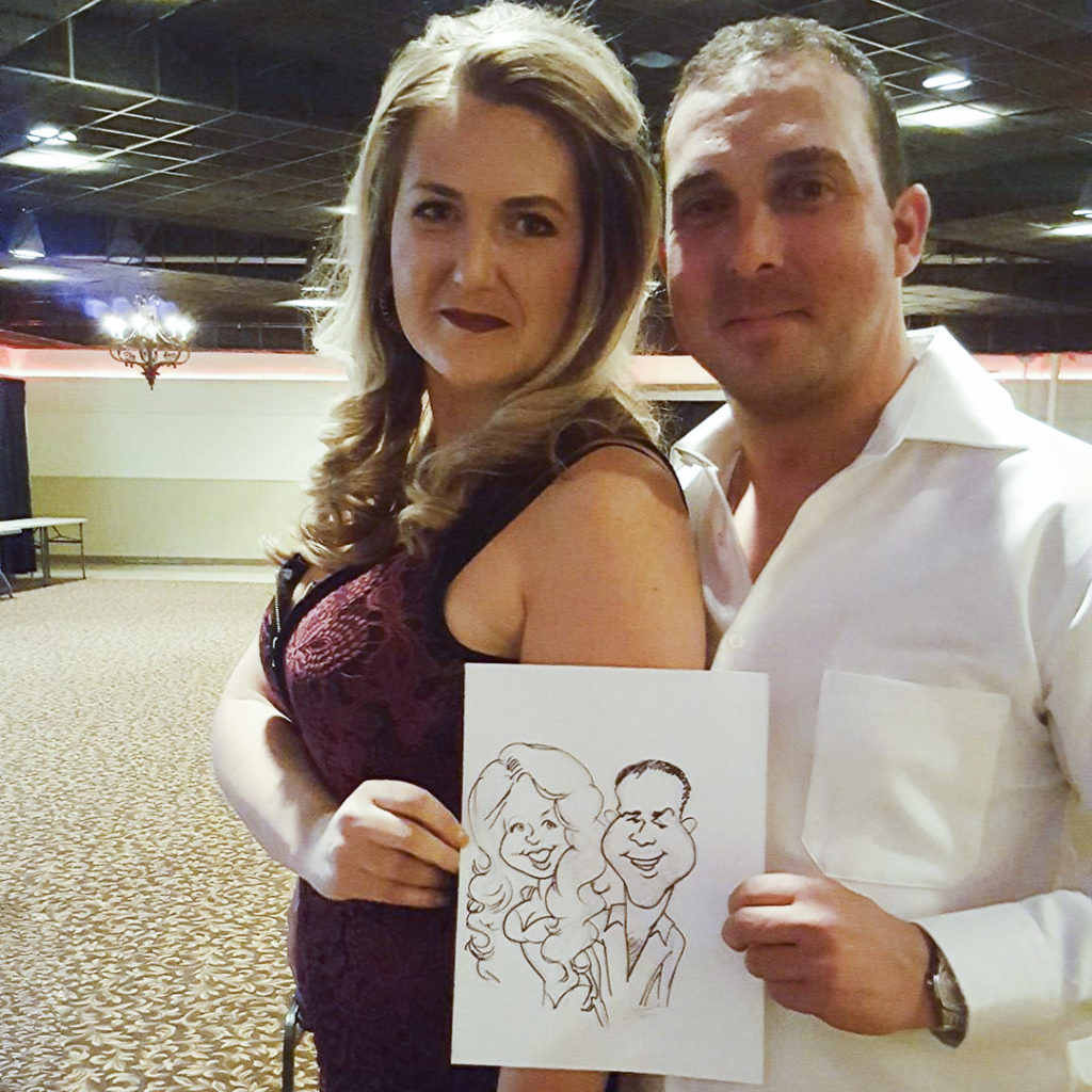 couple shows caricature artist drawing at wedding
