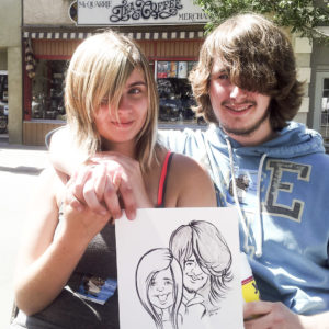 young couple holding their caricature outside of mcquarries saskatoon broadway