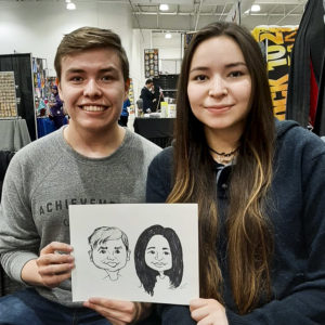 couple at a comic convention holding a caricature