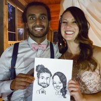 Couple at a wedding with their custom caricature art